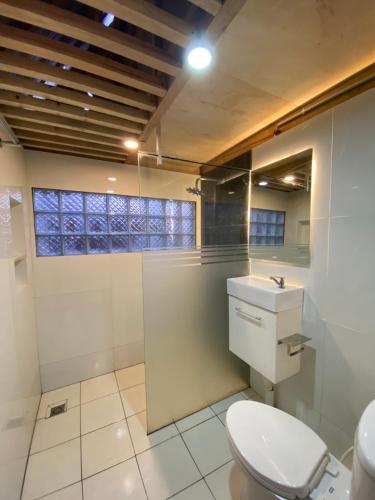 a bathroom with a toilet and a sink at Martos villa dieng in Dieng