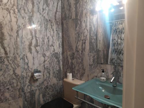 a bathroom with a sink and a toilet and a mirror at Apartamento junto a la Basilica del Pilar in Zaragoza