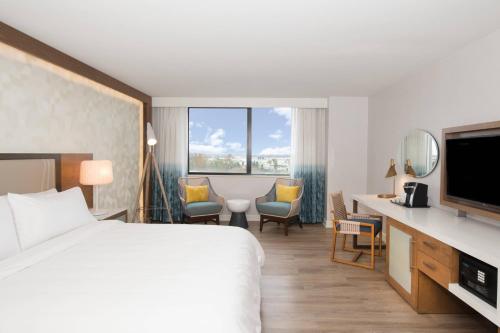 a hotel room with a bed and a television at Renaissance Newport Beach Hotel in Newport Beach