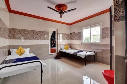 a bedroom with two beds and a window at SPOT ON Hotel Maha Lakshmi in Ongole