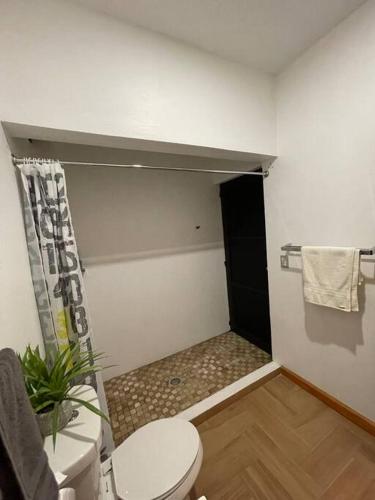 a bathroom with a toilet and a black door at Casa AbrahamMya Playa Linda 3 bed home with pool. in El Desengaño