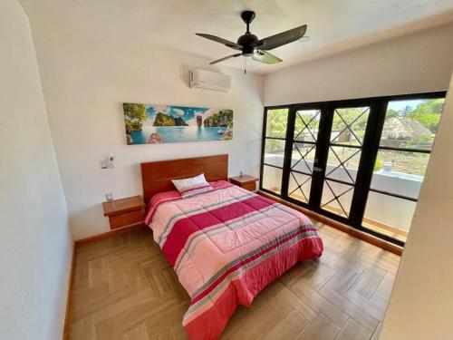 a bedroom with a bed and a ceiling fan at Casa AbrahamMya Playa Linda 3 bed home with pool. in El Desengaño