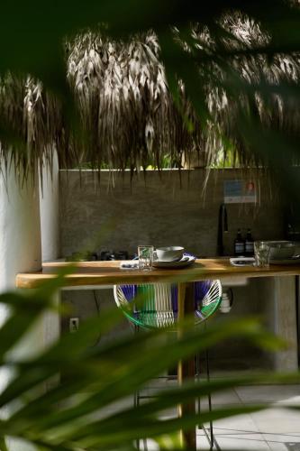 a wooden table with plates and glasses on it at Casa MexiBali, Palapa Queen in La Majahua