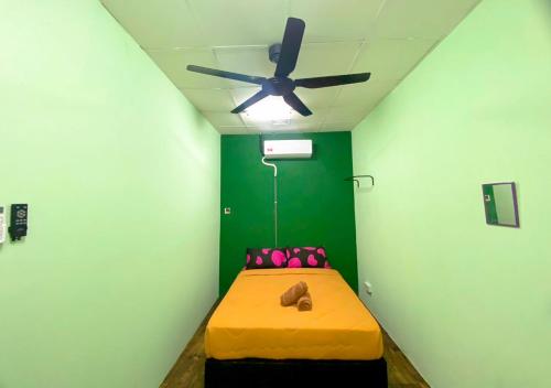 a room with a bed with a ceiling fan at HOSTEL BLACK88 Airport Transit - Self check in in Sepang