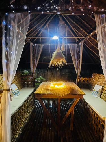 a wooden table in a room with a ceiling at La Palapa Inn Port Barton in San Vicente