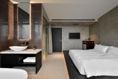 a bedroom with a large bed and a sink at Daybreak in Jiufen