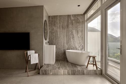 a bathroom with a tub and a large window at Daybreak in Jiufen