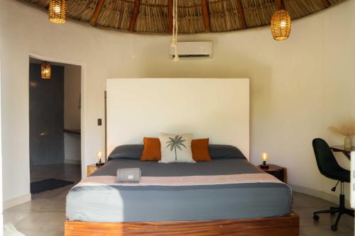 a bedroom with a large bed with two candles at Casa MexiBali, Palapita in Troncones