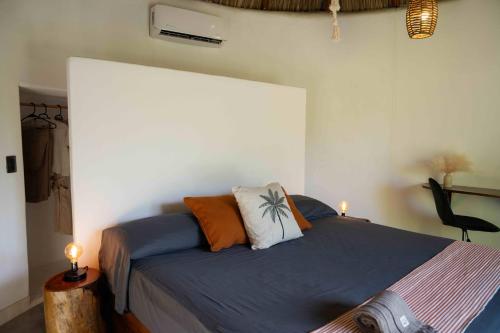 a bedroom with a bed with two pillows on it at Casa MexiBali, Palapa 47 in Troncones