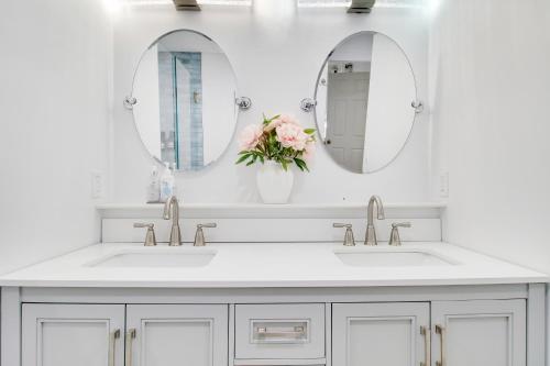 a bathroom with two sinks and two mirrors at Rockaway Beach House in West Palm Beach