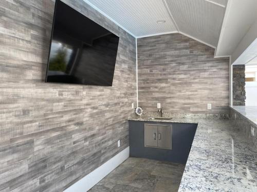 baño con lavabo y TV en la pared en Vacation Rental With Pool On Lbi, en Beach Haven