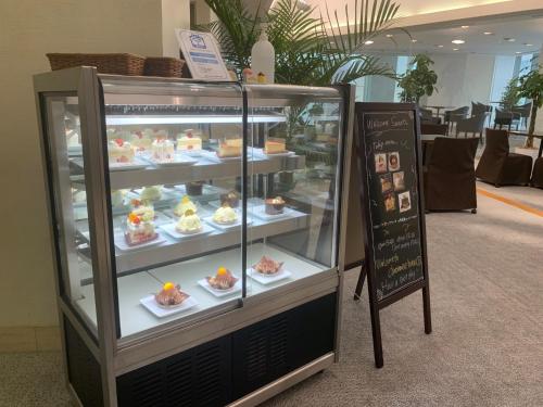 a display case with cakes and desserts on plates at Chateraise Hotel Nagano in Nagano
