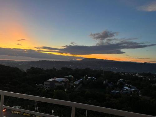 a view of a city at sunset from a balcony at Uptown Condo Primavera Residences in Cagayan de Oro