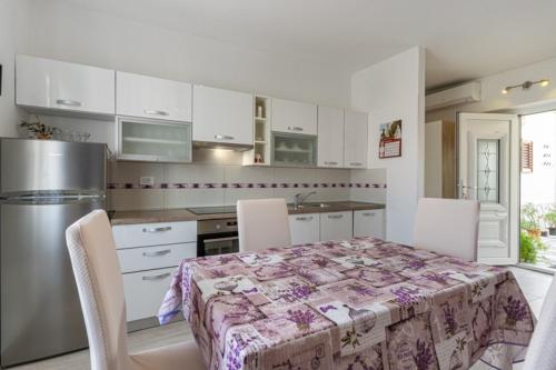 茨雷斯的住宿－Apartment Mici 2 - great loaction and relaxing，一间带桌椅的厨房和一间带白色橱柜的厨房