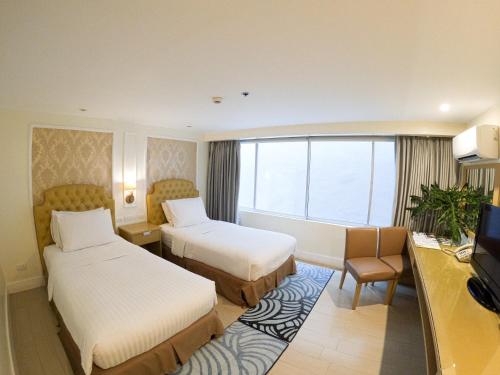 Habitación de hotel con 2 camas y TV en Hotel St. Ellis, en Legazpi