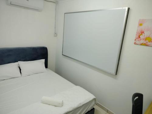 a small bedroom with a mirror and a bed at CMN Hotel & Homestay in Sungai Petani