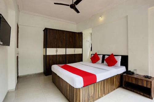 a bedroom with a large bed with red pillows at Hotel Lal Sai Residency in Mumbai