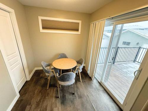 a dining room with a table and chairs and a balcony at 3 BDR - Bonus Room - King Bed - Garage - Near Airport in Regina