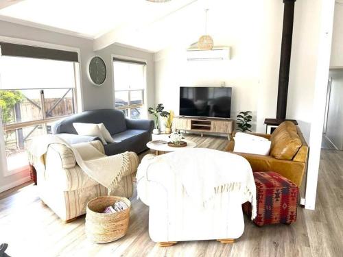 a living room with white furniture and a tv at Ocean Reach Cape Woolamai in Cape Woolamai