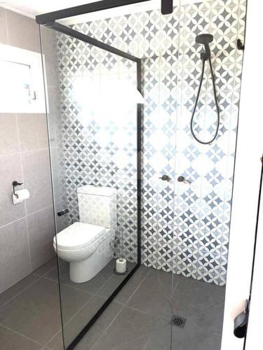 a bathroom with a toilet and a glass shower at Ocean Reach Cape Woolamai in Cape Woolamai