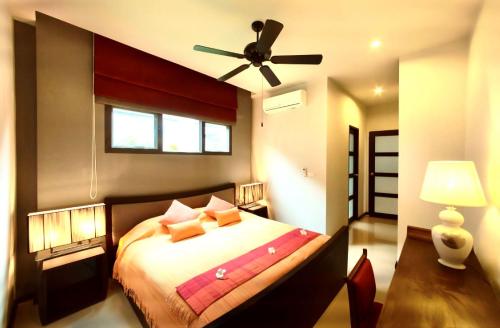 a bedroom with a bed with a ceiling fan at Вилла с бассейном на Най Харн, 2 спальни G3 in Rawai Beach
