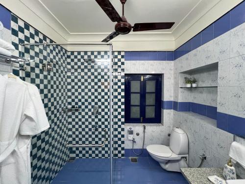 a bathroom with a toilet and a glass shower at Vijai Mahal - A Colonial Homestay in Ajmer
