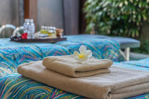 a towel with a flower sitting on top of a table at Asa Bali Luxury Villas & Spa in Seminyak