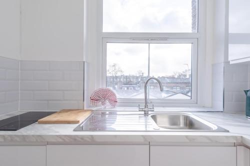 a white kitchen with a sink and a window at HAFH in Paddington - Double studio 2 in London