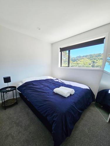 Un dormitorio con una gran cama azul y una ventana en New and Fabulous, City Fringe Bliss! en Wellington