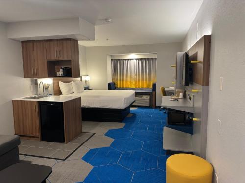 a large hotel room with a bed and a kitchen at Microtel Inn and Suites Independence in Independence