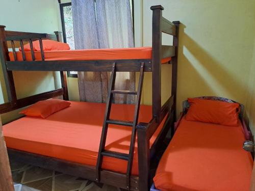 two bunk beds in a room with orange sheets at CASA EQUIPADA SAN IGNACIO DE ACOSTA 