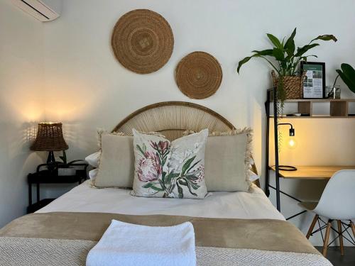 a bedroom with a bed with pillows and a desk at The Boshoff in Durban