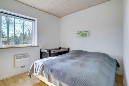 um quarto branco com uma cama e uma janela em Relaxing Vacation In Scenic Surroundings em Højby