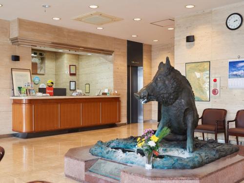 a statue of a dog in a hospital lobby at Tabist Hotel New Central in Fuji