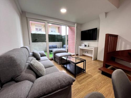 sala de estar con sofá y TV en Duplex con terraza en Renedo de Piélagos