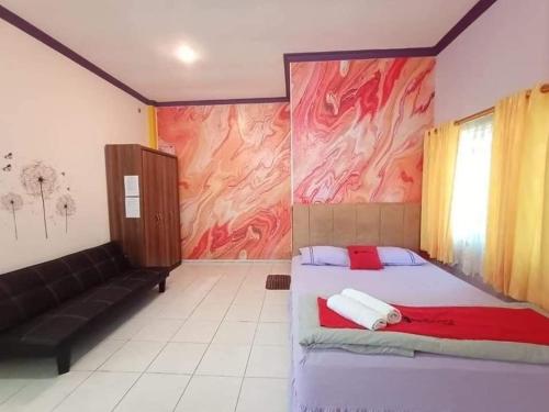 um quarto com uma cama e um sofá em Pavillion EMWEKA Balikpapan em Balikpapan