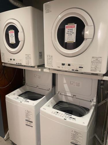 two washers and a dryer sitting on a shelf at Nawate Guesthouse in Matsumoto