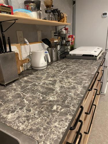 a kitchen counter with a marble counter top at Nawate Guesthouse in Matsumoto