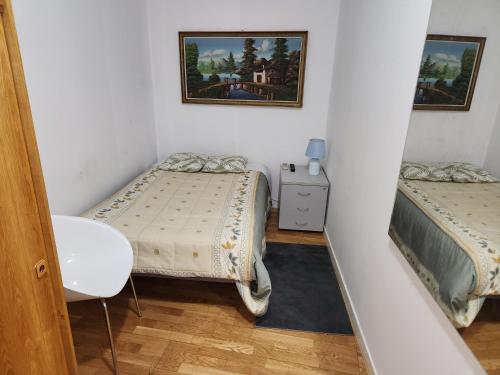 een kleine kamer met 2 bedden en een spiegel bij Hostel Pepe Viajes in Madrid