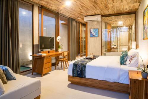 een slaapkamer met een bed, een bureau en een televisie bij Langit Pitu Villas in Ketewel