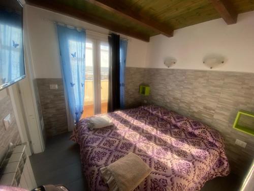 a bedroom with a bed with a purple comforter at La casa di Leila in Passoscuro