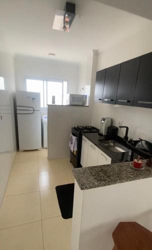 a kitchen with a refrigerator and a counter top at Apartamento Vila Tupi in Praia Grande