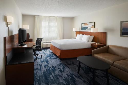 a hotel room with a bed and a couch at Fairfield Inn Huntsville in Huntsville