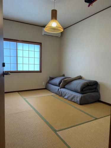 een slaapkamer met een bed in de hoek van een kamer bij Guesthouse Hakuka in Kanazawa