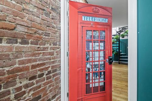 an old red phone booth next to a brick wall at The London Flat Capital Hill DC in Washington
