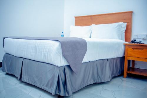 ein Schlafzimmer mit einem großen Bett und einem Holztisch in der Unterkunft Teranga Lodge and Restaurant in Ihumwa
