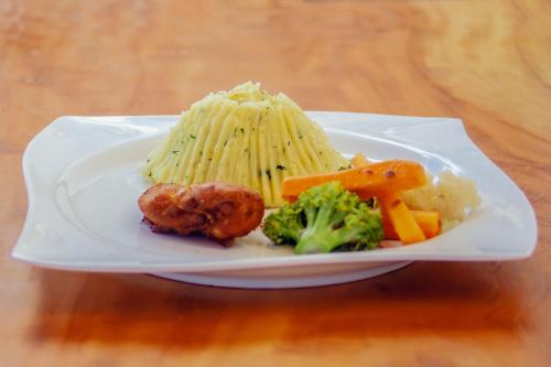 a plate of food with pasta and vegetables on a table at Teranga Lodge and Restaurant in Ihumwa