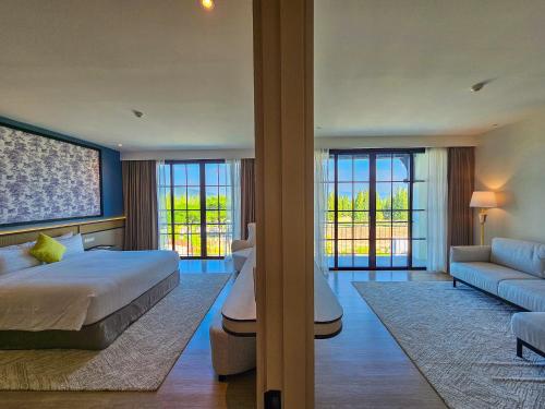 a hotel room with a bed and a couch at Estella Khao Yai in Khao Yai