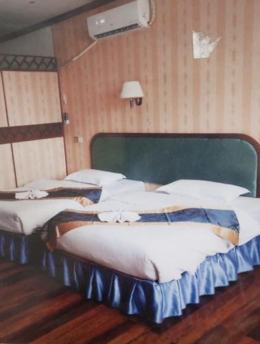 a group of three beds in a room at Dansavanh Hotel in Muang Xai
