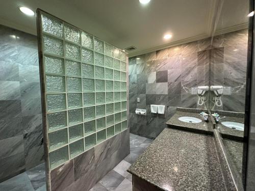 a bathroom with two sinks and a shower at Copa Hotel in Pattaya Central